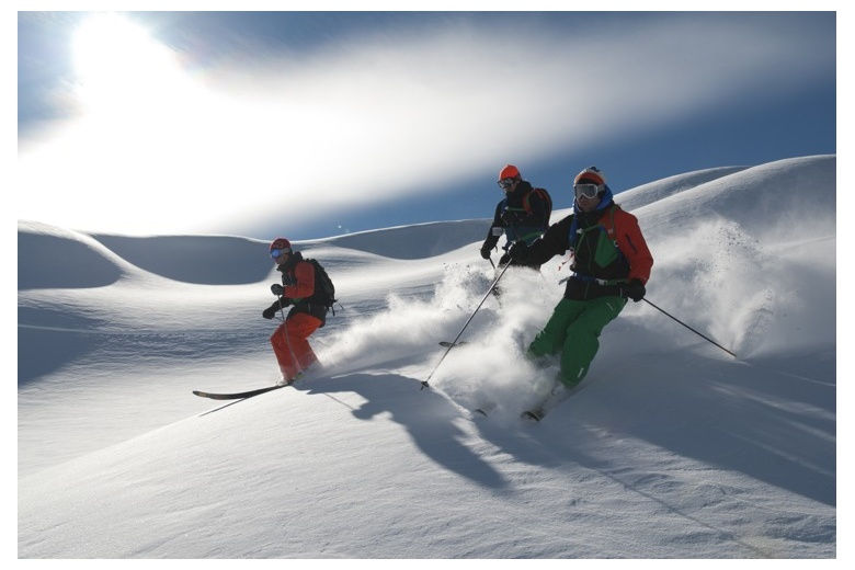 grupo de esquiadores bajando fuera pista en nieve fresca